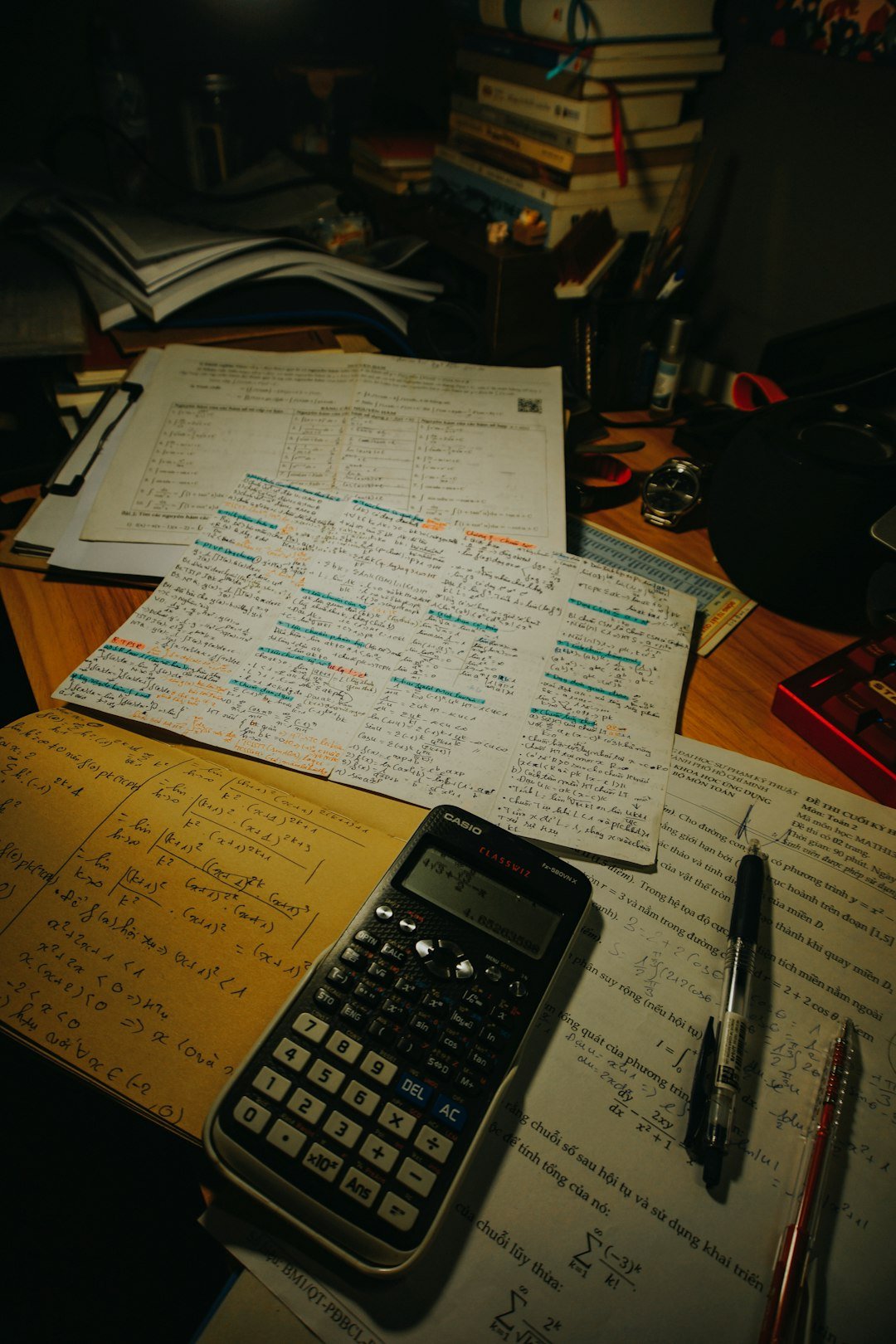 Calculator, study papers, pens and mathematics notes